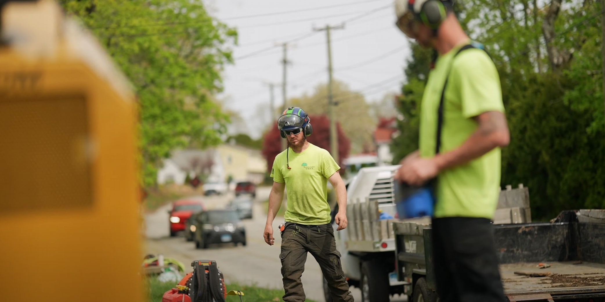 Tree service crew performing storm cleanup on residential street